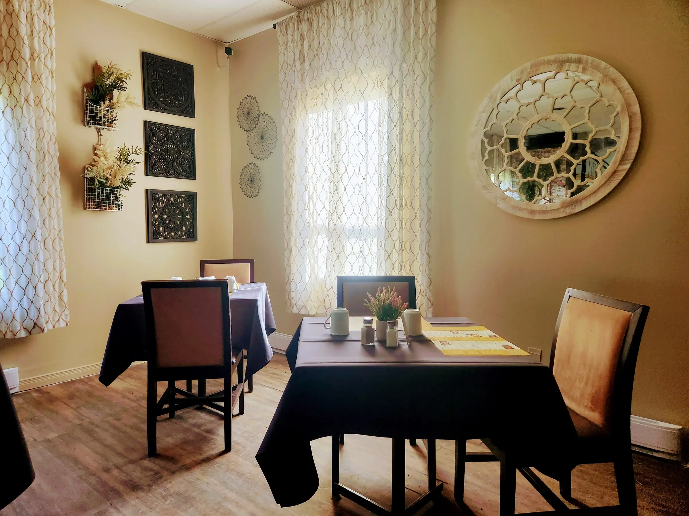 Salle à manger du restaurant Le 1889 avec tables dressées, éclairage chaleureux et miroir décoratif